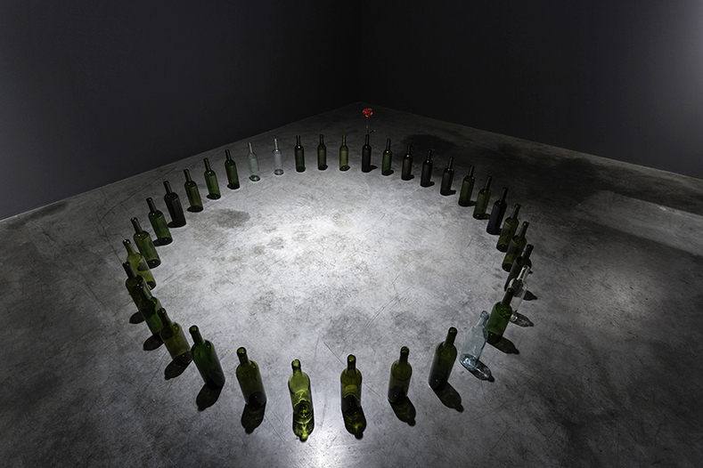 MARCO GODINHO, Every Day a Revolution, 2012, wine bottles and red carnation flowers, dimensions variable. Courtesy Grey Noise, Dubai.