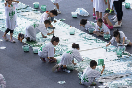 Excited children drawing with algae paint on xuan paper. Courtesy Gu Wenda Studio.