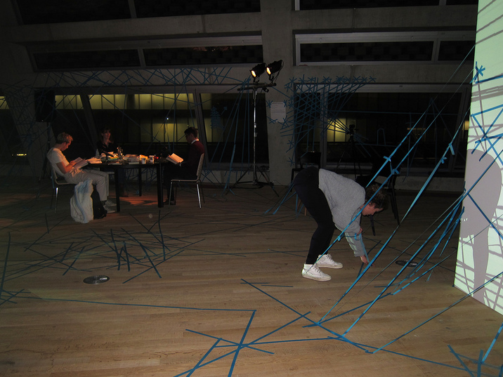 RAQS MEDIA COLLECTIVE’s Unbroken Reading (2016) performance recites the chosen texts in background, as a participant with tape make their mark.