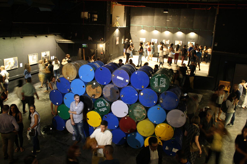 The opening of the “People of the Sea,” organized by the Arab Culture Center, in Hafia, with MANAL MAHAMID’s installation of oil drums and photographs, Corner Stone (2016), in the center.