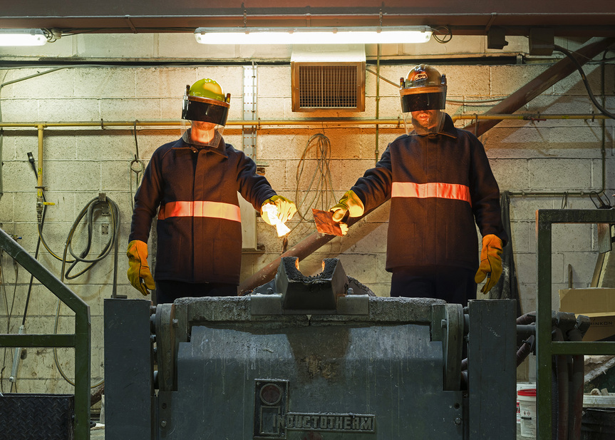 SAYED SATTAR HASAN and KARL OHIRI stand before a melting pot that was used in the creation process of My Granddad’s Car (2011– ). Courtesy the artists and Southbank Centre, London.