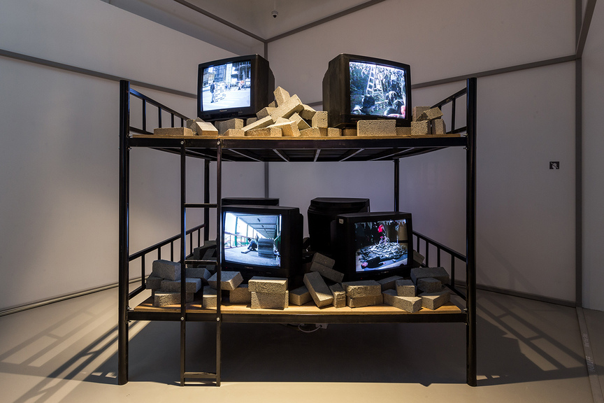 LIN YILIN, Hotbed, 2013, steel-frame bunk bed, bricks, six-channel video with color and sound. Courtesy M+, Hong Kong.