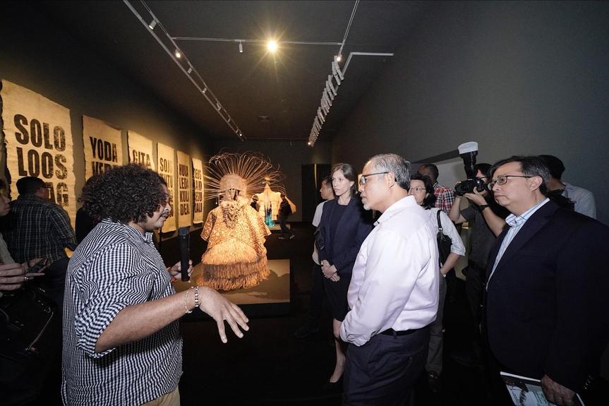 Artist NEWELL HARRY discussing his work with guest-of-honor minister MASAGOS ZULKIFLI from the Ministry of the Environment and Water Resources Singapore (center) and professor ALAN CHAN, dean of the Nanyang Technological University’s College of Humanities, Arts, and Social Sciences (right), at “Art After Dark,” NTU Centre for Contemporary Art Singapore, 2018. Courtesy NTU Centre for Contemporary Art Singapore.