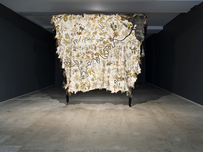 Installation view of CAROL MCGREGOR’s Skin Country, 2018, possum skins, charcoal, ocher, binder medium, waxed thread, 2.82 × 2.66 m, at “The Commute,” Institute of Modern Art, Brisbane, 2018.