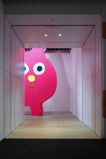 Installation view of TAKEHIRO IIKAWA’s Decoratorcrab – Mr. Kobayashi, the Pink Cat, 2019, fluorescent paint, wood, 550 × 675 × 70 cm, at Roppongi Crossing 2019: Connexions, Mori Art Museum, Tokyo, 2019.