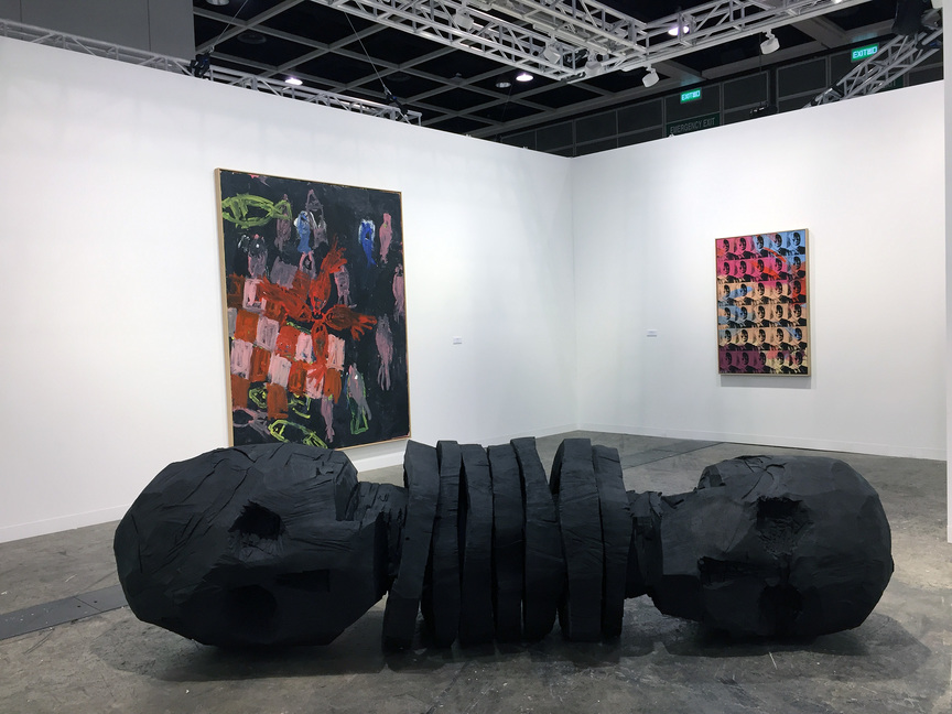 (Clockwise from foreground) GEORG BASELITZ’s black-burnished, bronze sculpture Zero Ende (2013) and oil-on-canvas Kopf an Kopf II (1989) along with ANDY WARHOL’s 30 Colored Maos (Reversal Series) (1980) at Galerie Thaddaeus Ropac (London / Paris / Salzburg).