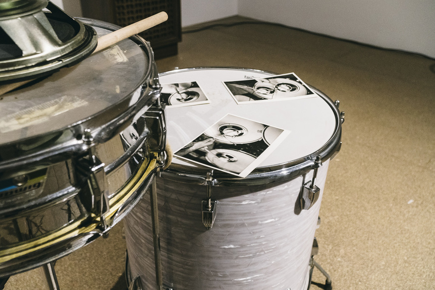 Detail installation view of PETER KENNEDY’s Snare, 1972/2019, snare drum, side drum, chair, amplifier, tape deck, speakers, drumstick, three photographs, approximately 300 × 120 × 80 cm, at “There Then Here Now,” Milani Gallery, Brisbane, 2019.