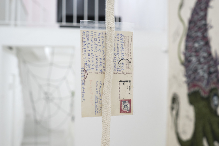 Detailed installation view of COLLECTIVE OF FICTIONAL INDIVIDUALS’ I cry for you, 2019, found postcard sent from Los Angeles to Hong Kong in 1965, rope, inkjet printed photograph of a serval scanned from an animal encyclopedia published in 1972, dimensions variable, at “ICRY4U,” TARS Gallery, Bangkok, 2019.