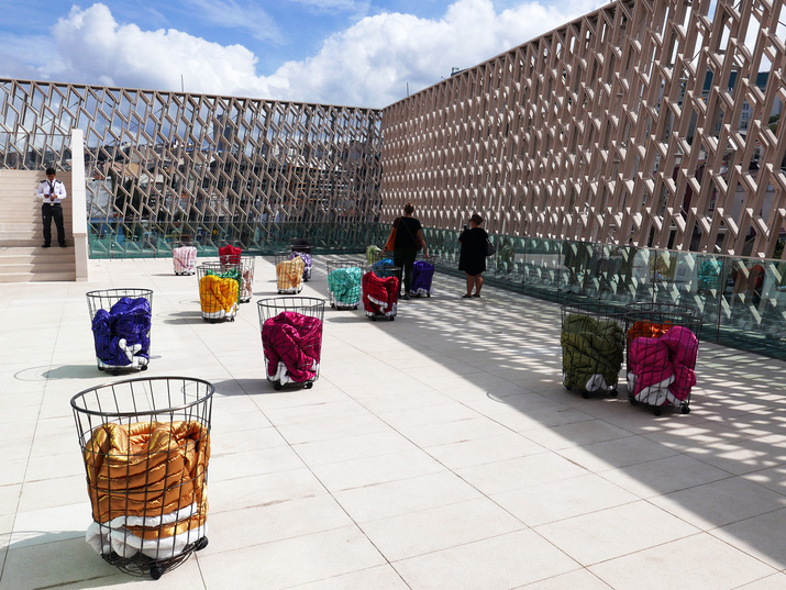 GÜLSÜN KARAMUSTAFA, Mystic Transport, 1992, 20 movable metal baskets, satin quilts, 90 × 60 × 45 each.