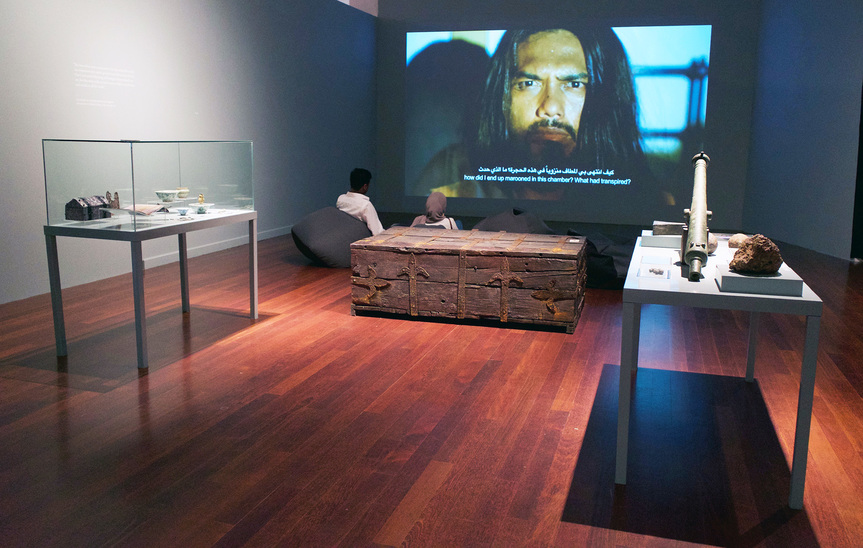 Partial installation view of AHMAD FUAD OSMAN’s Enrique de Malacca Memorial Project, 2016/19– , bronze finished fiberglass casting, oil paintings on canvas, carved marlin bone, scale model of the Trinidad (Magellan’s ship), single-channel video projection, 36 video interviews on 3 iPads, old Malay weapons, 16th century canon and canon balls, 16th century Ming ceramics, 16th century Portuguese and Malacca coins, 16th century world and Southeast Asia maps and prints, UV prints on aluminum, 16th century navigational objects, wall texts, vitrines, dimensions variable, at “At the End of the Day Even Art Is Not Important,” National Art Gallery, Kuala Lumpur, 2020.