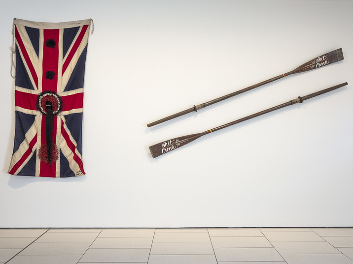 Installation view of KARLA DICKENS’s Jack and Jill (A.K.A. Hung, strung and quartered), 2016, Union Jack flag, shells, hair, two paddles, dimension variable, at “Rite of Passage,” QUT Art Museum, Brisbane, 2020. Courtesy the artist and Andrew Baker Art Dealer, Brisbane.