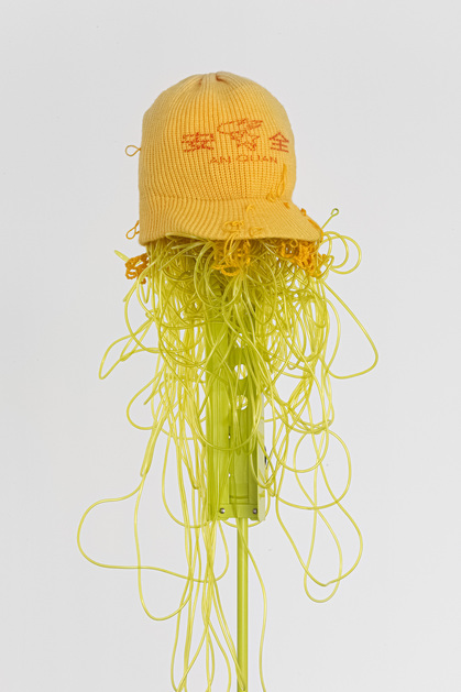 Detailed installation view of SHIRLEY TSE’s An Quan, 2020, beanie, yarn, polyethylene tube, and music stand, dimensions variable, at “Stake and Holders,” M+ Pavilion, Hong Kong, 2020. Photo by Ringo Cheung. Courtesy the artist and M+, Hong Kong.